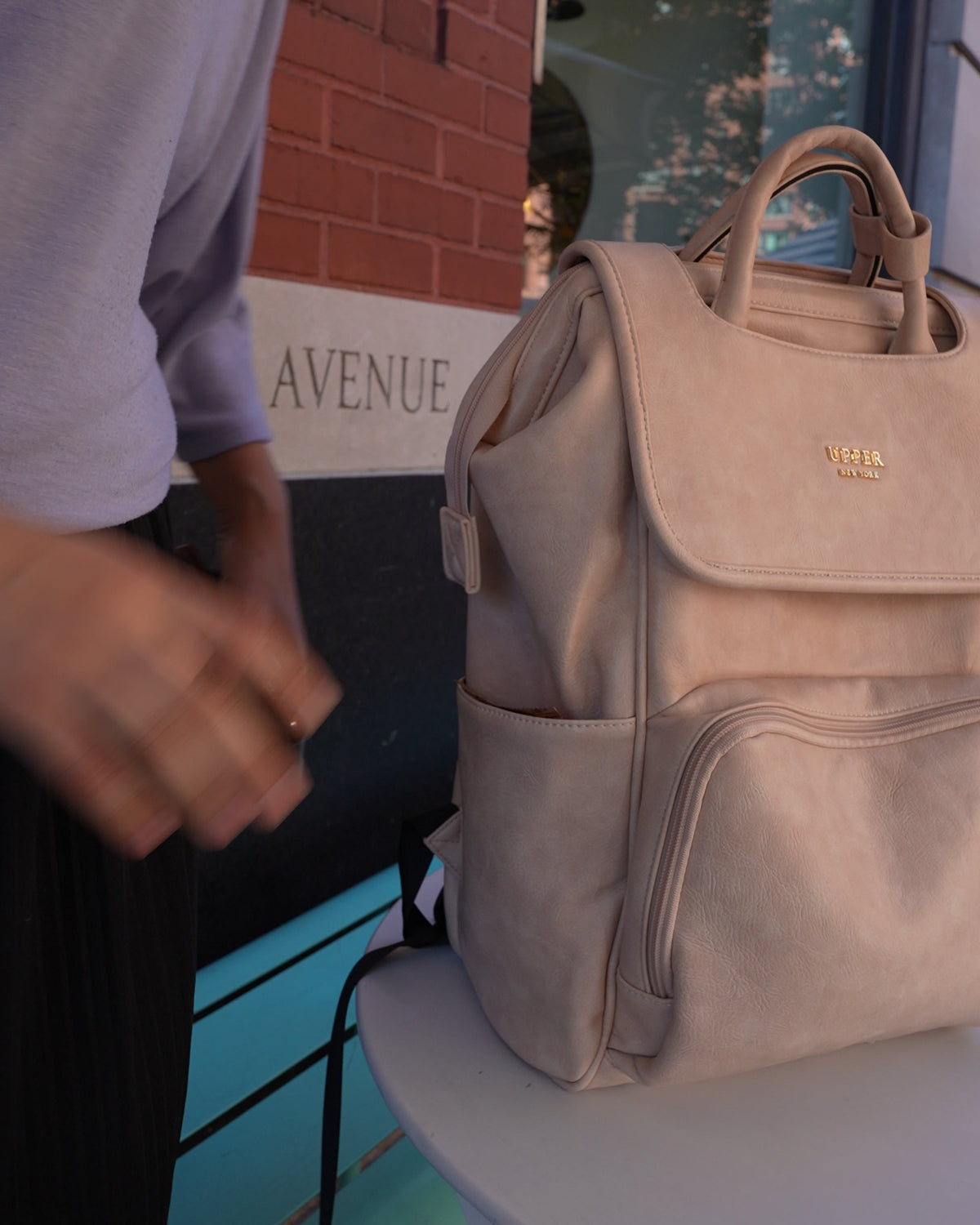 Commuter 23 backpack in taupe set on a table at work, for parents on the go