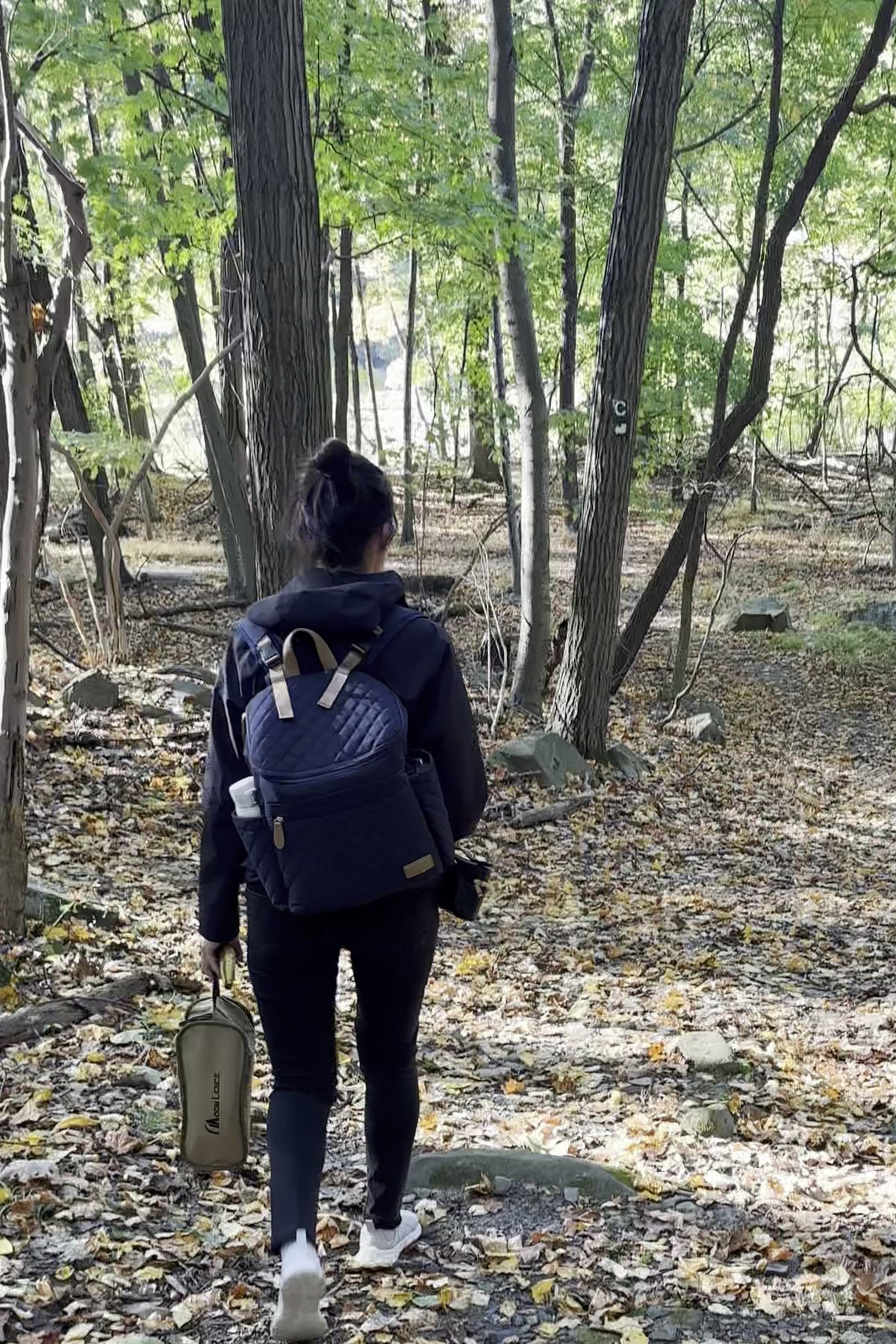 Parent wearing Maison Air backpack on a woodland walk