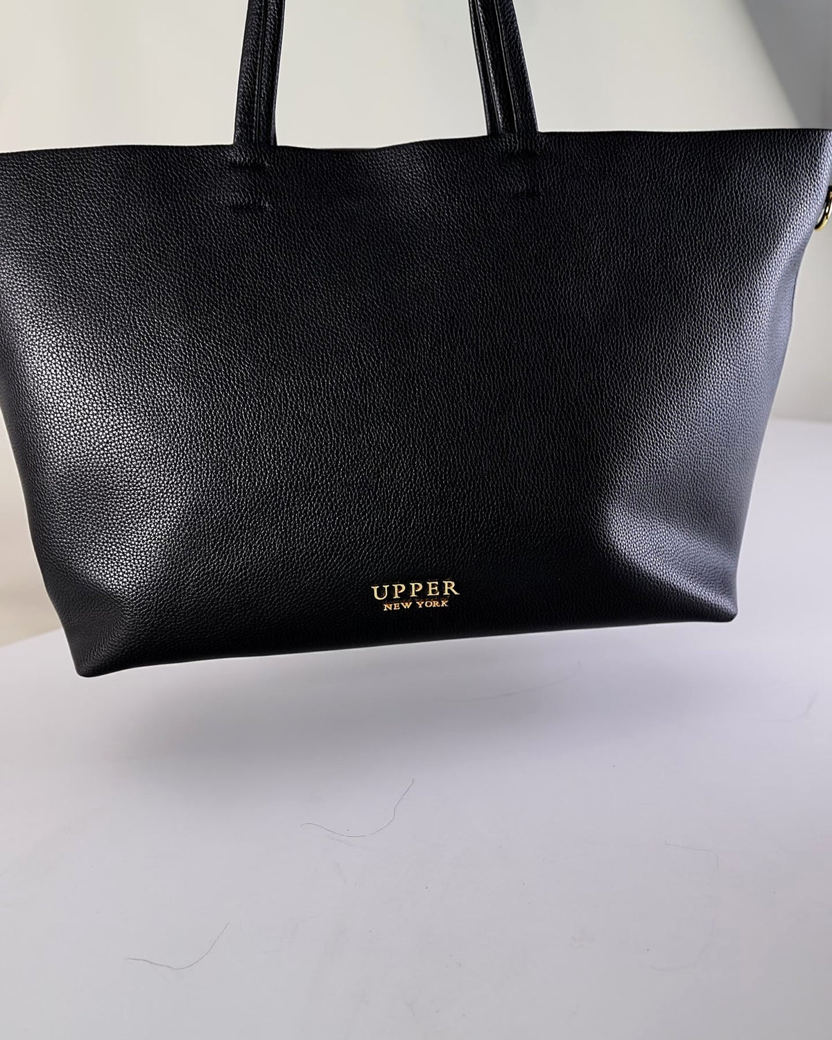 Carry-on tote in black vegan leather with shoulder handles, front view